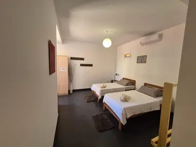 a hotel room with two beds and a hallway at Apart Laginha Tess & To in Mindelo