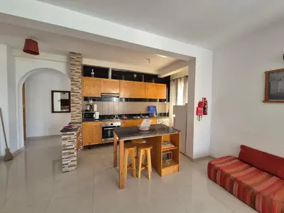 a kitchen and living room with a table and a couch at Apart Laginha Tess & To in Mindelo