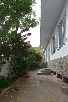 a walkway next to a building with plants and flowers at Apart Laginha Tess & To in Mindelo