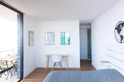 a bedroom with white walls and a table and chairs at 3 bdr aprt, stunning seaview, rooftop pool - LCGR in Praia