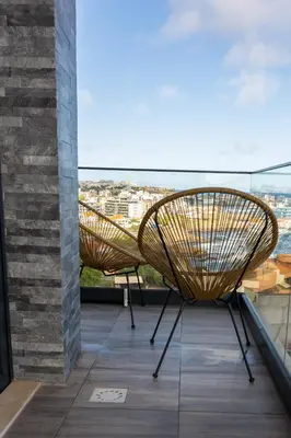 a pair of chairs sitting on a balcony at 3 bdr aprt, stunning seaview, rooftop pool - LCGR in Praia