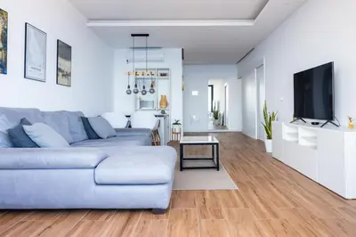 a living room with a couch and a tv at 3 bdr aprt, stunning seaview, rooftop pool - LCGR in Praia