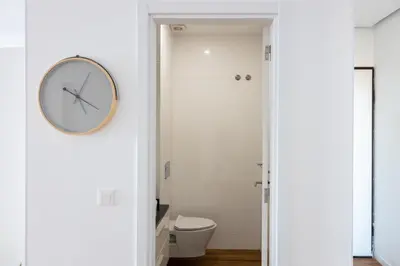 a bathroom with a toilet and a clock on the wall at 3 bdr aprt, stunning seaview, rooftop pool - LCGR in Praia