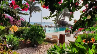 a resort swimming pool with a beach and the ocean at Beach front ocean view Porto Antigo2 Santa Maria in Santa Maria