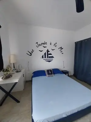 a bedroom with a bed and a desk with a sign on the wall at LA VELA in Palmeira