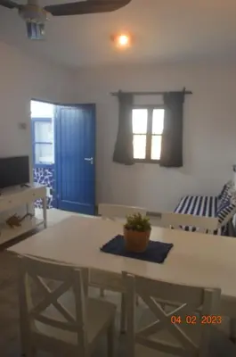 a living room with a table and chairs and a tv at LA VELA in Palmeira