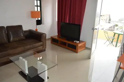 a living room with a couch and a television at Apartamento t1 mobiliado com Wi-Fi in Praia
