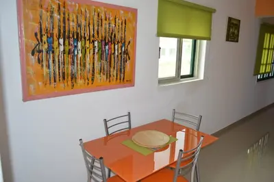 a dining room table with chairs and a painting on the wall at Apartamento t1 mobiliado com Wi-Fi in Praia
