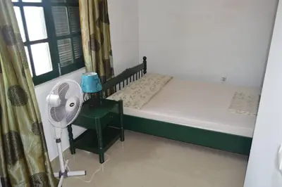 a bedroom with a bed and a fan and a window at Apartamento t1 mobiliado com Wi-Fi in Praia