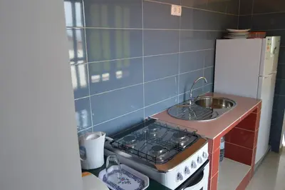 a small kitchen with a stove and a sink at Apartamento t1 mobiliado com Wi-Fi in Praia