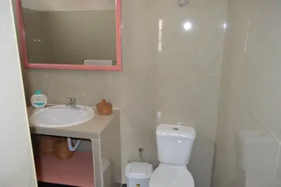 a bathroom with a sink and a toilet and a mirror at Apartamento t1 mobiliado com Wi-Fi in Praia