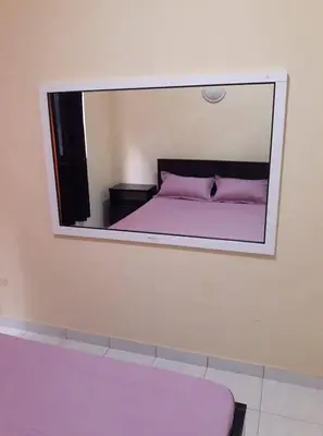 a mirror on a wall with a bed in a room at Casa Familiar Pôr do Sol in Ribeira Grande