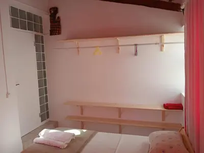 a small room with a bed and a bench at Maya Apartments in Mindelo