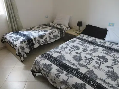 a room with two beds and a bed istg at Adult only beachfront 2 bedroom apartment Santa Maria airport pick up, aircon, unlimited wifi ideal for remote working and long stay in Santa Maria