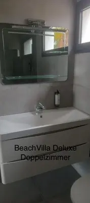 a bathroom with a white sink and a mirror at Luxury Beach Villa, Praia de Chaves, Boa Vista in Boa Ventura