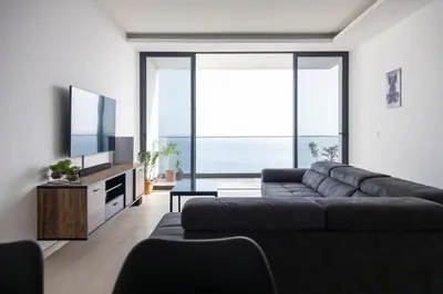 a living room with a couch and a flat screen tv at 3 bdr aprt, amazing seaview, rooftop pool - LCGR in Praia