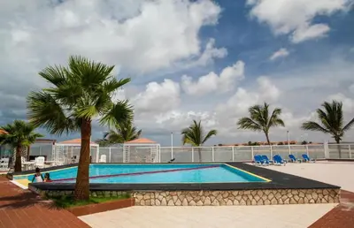 a large swimming pool with palm trees and a building at Murdeira Village V155A in Beirona
