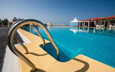 a swimming pool with a bench in the water at Murdeira Village V155A in Beirona