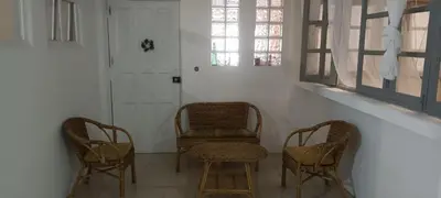 two chairs and a chair in a room with a door at Kaza Jindung in Mindelo