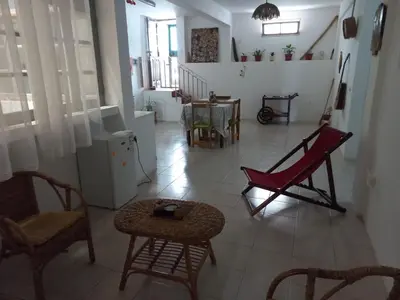 a living room with a red chair and a table at Kaza Jindung in Mindelo