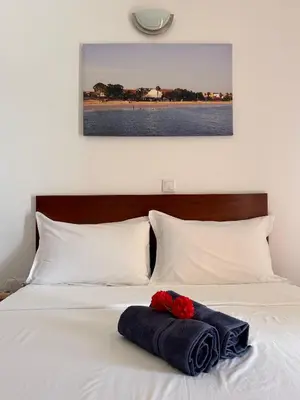 a white bed with two red roses on it at Casa Maria Apartments in Santa Maria