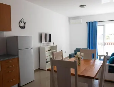 a kitchen and dining room with a table and a refrigerator at Casa Maria Apartments in Santa Maria