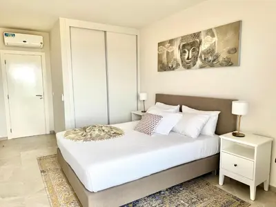 a bedroom with a large bed with white sheets and pillows at SunSet in Santa Maria