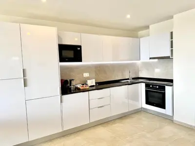 a white kitchen with white cabinets and appliances at SunSet in Santa Maria