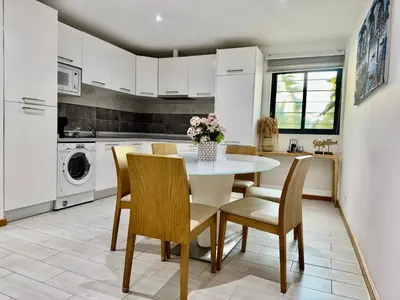 a kitchen with a table and chairs and a kitchen with white cabinets at Sunrise in Santa Maria