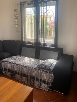 a bed in a room with a window and a table at Villa GÊMEO vue mer, piscine accès privé plage in Calheta Do Maio