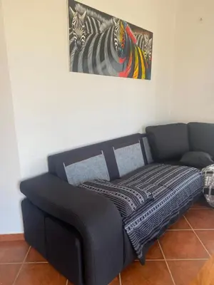 a black couch sitting under a painting on a wall at Villa GÊMEO vue mer, piscine accès privé plage in Calheta Do Maio