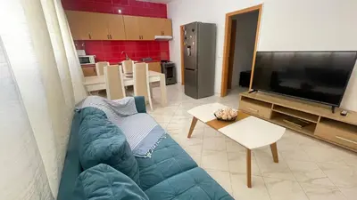a living room with a blue couch and a tv at Quick Stay in Praia #2 in Praia