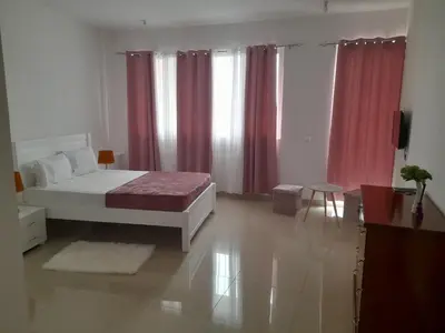 a bedroom with a bed and red curtains at Splanada poilon in Assomada