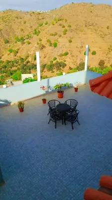 a patio with two chairs and a table and a hill at Splanada poilon in Assomada