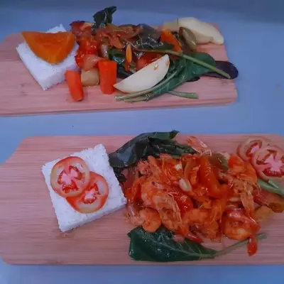 two plates of food with shrimp and vegetables on them at Splanada poilon in Assomada