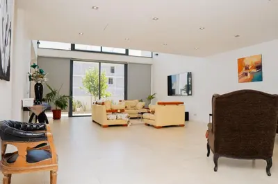 a living room with yellow chairs and a couch at Kriol Guest House in Praia
