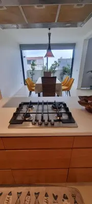a kitchen with a stove with a table and chairs at Kriol Guest House in Praia