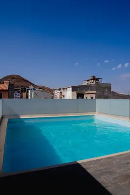 a swimming pool on the roof of a building at Kriol Guest House in Praia