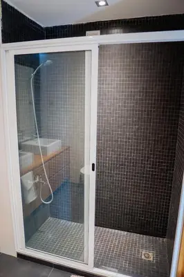 a shower with a glass door in a bathroom at Kriol Guest House in Praia