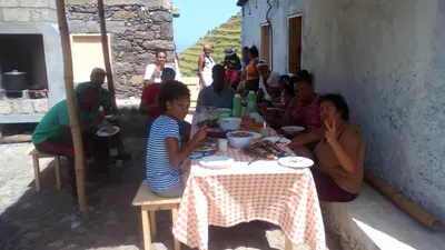 a group of people sitting at a table eating at Pousada Dragoeiro Monte Joana Santo Antão in Ribeira Grande
