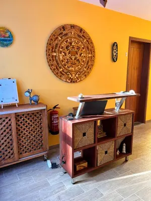 a room with a yellow wall with a laptop on a shelf at Orietta Residencial in Mindelo