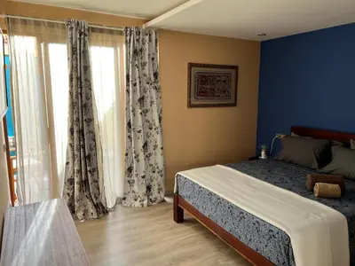 a bedroom with a bed with blue walls and curtains at Orietta Residencial in Mindelo