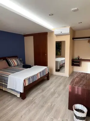 a large bedroom with a bed and a mirror at Orietta Residencial in Mindelo