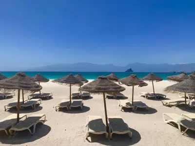a group of chairs and umbrellas on a beach at Bellavista in Mindelo