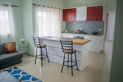 a kitchen with a counter and two bar stools at Comfortable and Cozy Apartments in Praia