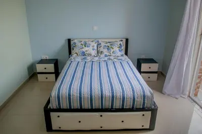 a bed in a bedroom with two night stands at Comfortable and Cozy Apartments in Praia