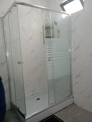 a shower stall with a glass door in a room at Kaza Mamai di Fora in Calheta de São Miguel