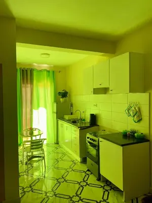 a kitchen with white cabinets and a table and a chair at Aluguer apartamento in Santa Maria