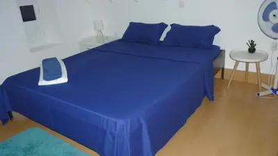 a blue bed with a blue blanket and a table at KAZARÃO DI MAVETE- Guesthouse in Praia