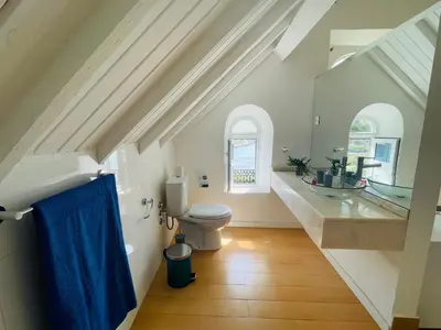 a bathroom with a toilet and a blue shower curtain at KAZARÃO DI MAVETE- Guesthouse in Praia